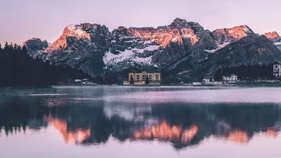 Scenic view of Misurina Lake with mountain reflections at sunrise in Veneto, Italy.