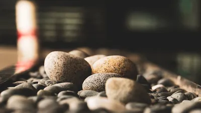 A serene close-up of smooth mixed-color pebbles, offering a calming aesthetic with soft focus background.