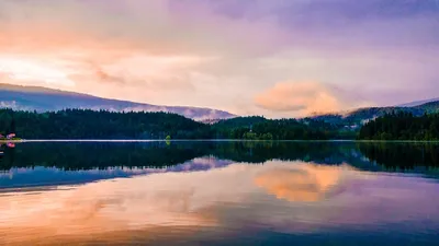 Vibrant sunset over a tranquil lake with mountain reflections in Clearwater, BC.