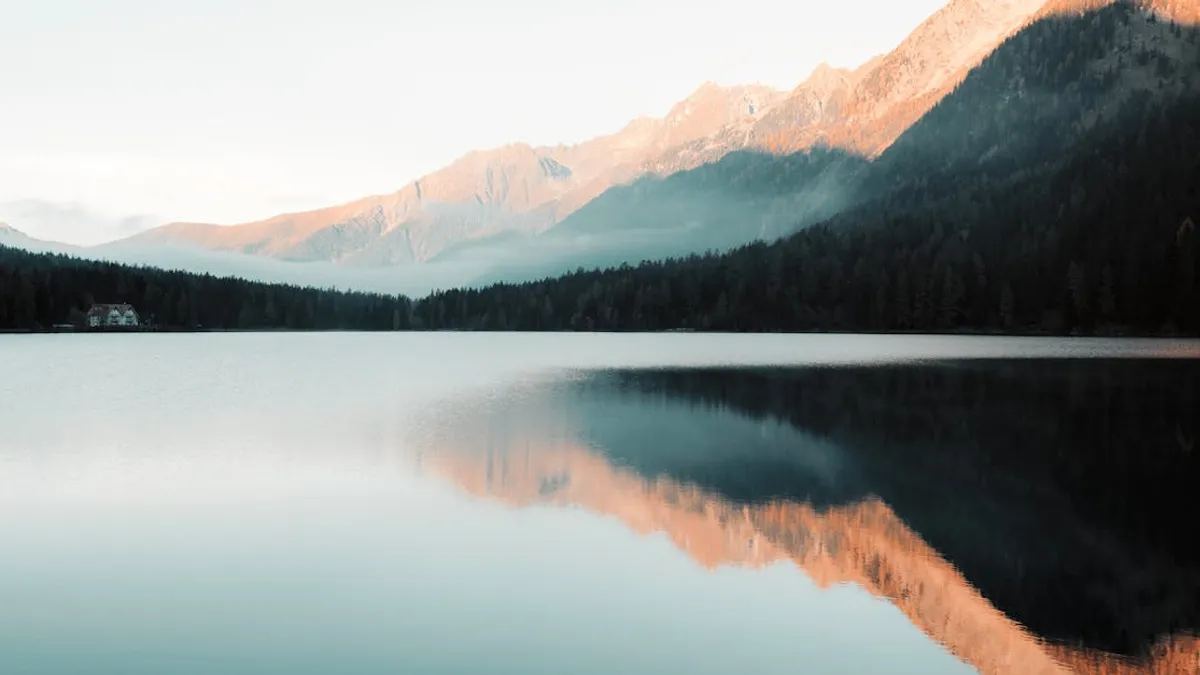 Peaceful morning view of a mountain lake with perfect reflections and misty ambiance.